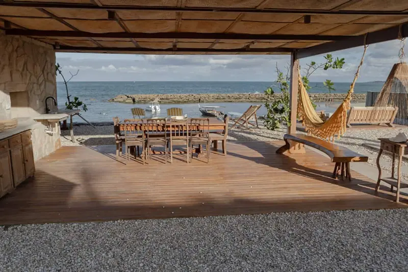 Área gourmet aberta para o mar, com rede e mesa comprida