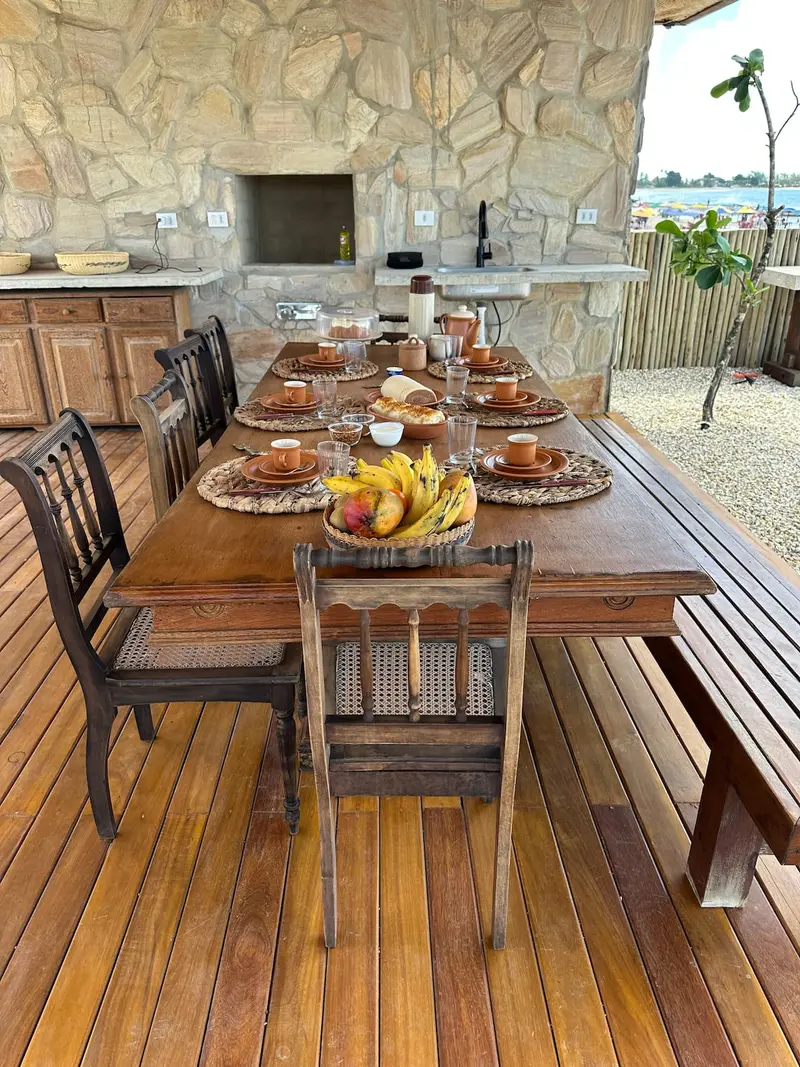Mesa posta ao lado da churrasqueira de pedra