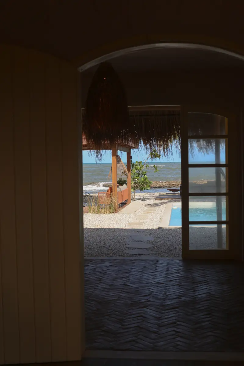 Porta em arco aberta para a piscina e o mar