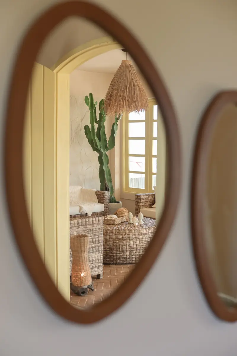 Sala refletida no espelho de moldura de madeira
